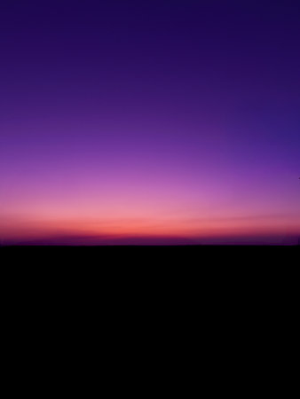 A purple sky with a purple and orange horizon and a purple cloud.