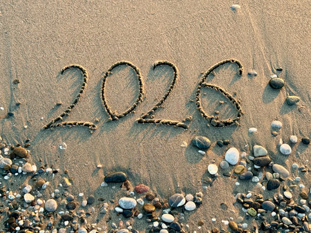 2026 new year concept. 2026 Written in Sand on a Beach with Golden Sunset Reflection.