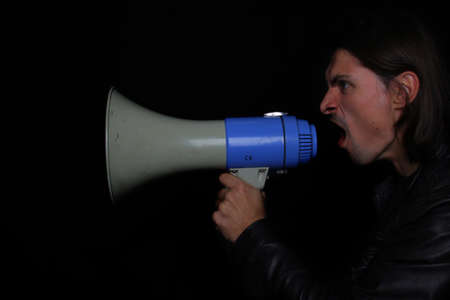 man shouting into a shout on a dark background