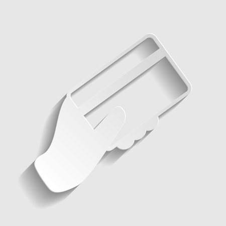 Hand holding a credit card. Paper style icon with shadow on gray.のイラスト素材