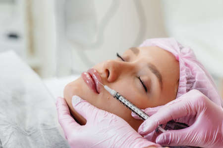 Cosmetology procedure for lip augmentation and wrinkle removal for a young beautiful girl....