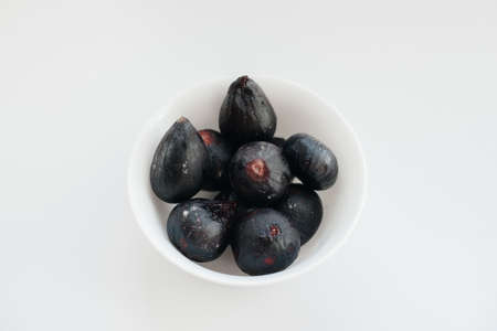 Ripe and sweet figs cut and arranged in a plate on a white background with free space. Fruits and vegetarianismの写真素材