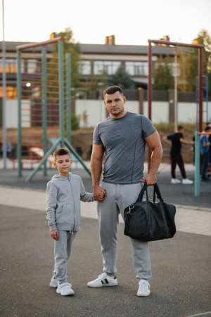 Father and son stand on the sports field after training during sunset. Healthy lifestyleの写真素材