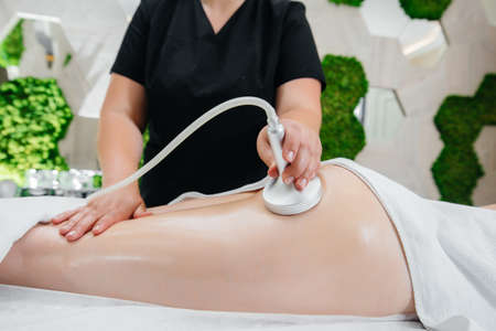 A young pretty girl is enjoying a professional vacuum massage at the Spa. Body care. Beauty salonの写真素材