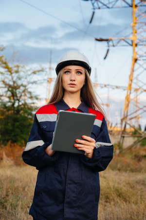 A young engineering worker inspects and controls the equipment of the power line. Energyの写真素材
