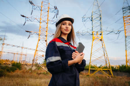 A young engineering worker inspects and controls the equipment of the power line. Energyの写真素材