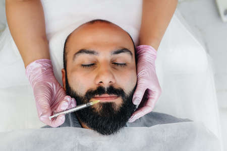 Cosmetic procedure for lip augmentation and wrinkle removal for a bearded man. Cosmetologyの写真素材