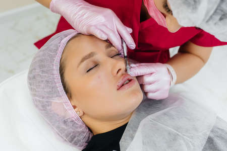 Cosmetology procedure for lip augmentation and wrinkle removal for a young beautiful girl. Cosmetologyの写真素材
