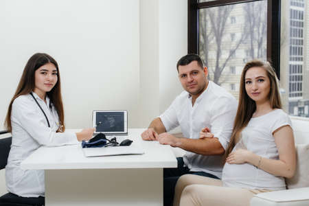A young couple waiting for a baby to consult a gynecologist after an ultrasound. Pregnancy, and health careの写真素材