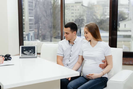 A young couple at a gynecologist's consultation after an ultrasound. Pregnancy, and health careの写真素材