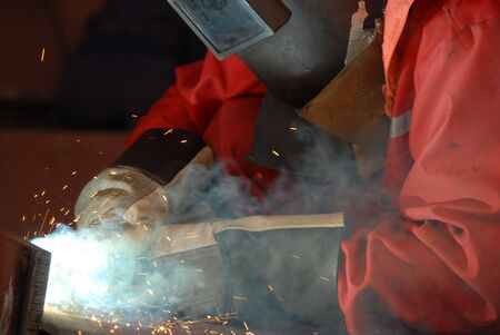 Worker welding steel in a mechanical workshop