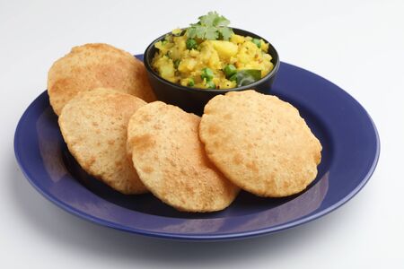 Indian food ,  puri with potato curry served in a blue ceramic plate  & bowlの写真素材