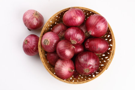 Red onions in a basket on white background, top view, horizontalの写真素材