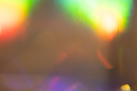 Holographic multicolored background. Defocused light leaks and lens flare. Can be used as a background, overlay or screen mode to create a retro and vintage effect.の写真素材
