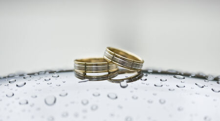 Golden rings on chrome surface with water drops 