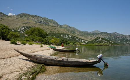 Small wooden boats on the sandy beach of Skadarsko lake - Montenegro. のeditorial素材