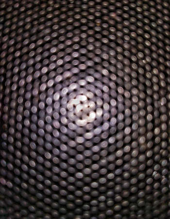A Black shinny Round Pattern Grill on which white light is flashing at centre. Large number of round...