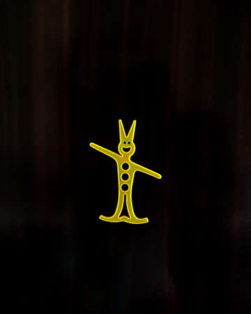 A yellow color Smiling Human cartoon with one hand up and other down with black background.の写真素材