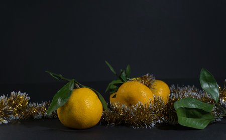 Tangerine cut with a green leaf on a black backgroundの写真素材
