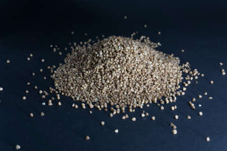 Scattered buckwheat grains on a black background