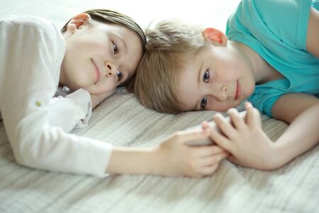 Boy and girl looking at a smart phoneの写真素材