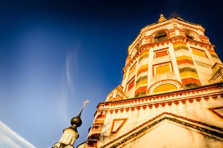 Old multicolored bell tower at sunsetのeditorial素材