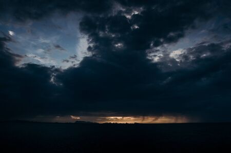 Flashes of lights in dark stormy sea above beach of Phangan island.