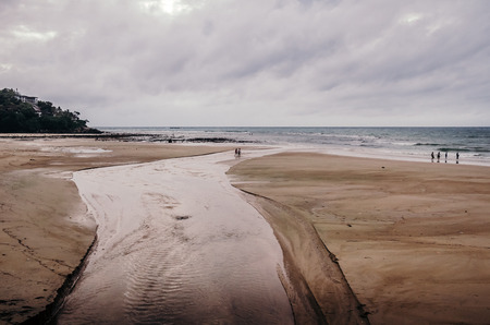 Spacious sandy beach of Karon in low tide and people walking around, Phuket island.の写真素材
