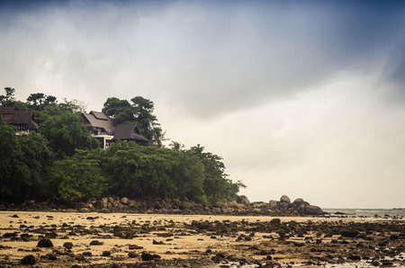 Prolonged beach with rocks and house on hill above, Kamala beach.の写真素材