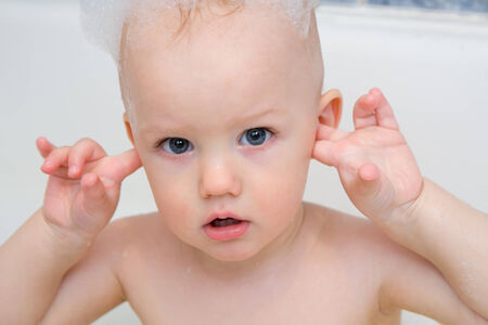 Little boy having a bath with soap foamの写真素材