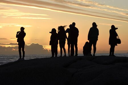 Group of tourists watching the sunset in Camps Bay, Cape Town, South Africaの写真素材