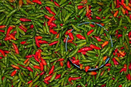 Red and green peppers in a market placeの写真素材
