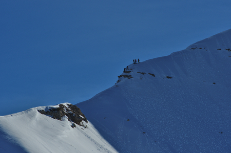 People climbing the mountain in Italian Alps, with snowshoes or skiの写真素材