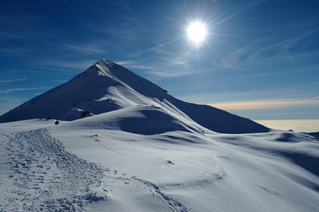 Snowy mountain scenery in the Italian Alps, in sunny day with low cloud in the backgroundの写真素材