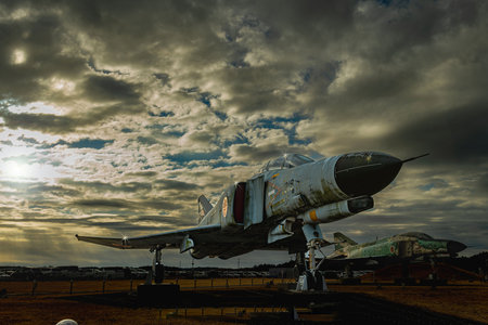 Rays of light pour down from between dramatic clouds. Decommissioned fighter F-4Ej Phantom II at Ibaraki Airport, Japanのeditorial素材