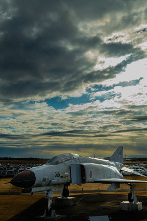 Rays of light pour down from between dramatic clouds. Decommissioned fighter F-4Ej Phantom II at Ibaraki Airport, Japanのeditorial素材