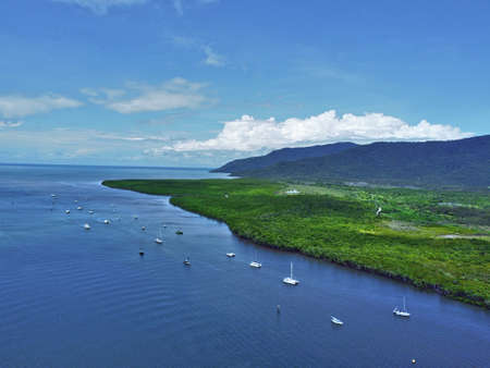 Aerial view of Ocean and boats with a mountain backdropの写真素材