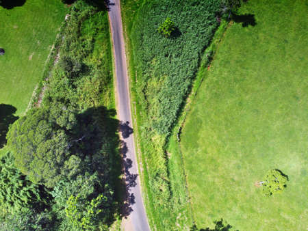 Downward aerial view of road between fieldsの写真素材