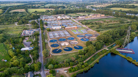 Aerial view of water treatment plant, surrounded by river, nature and farming fields