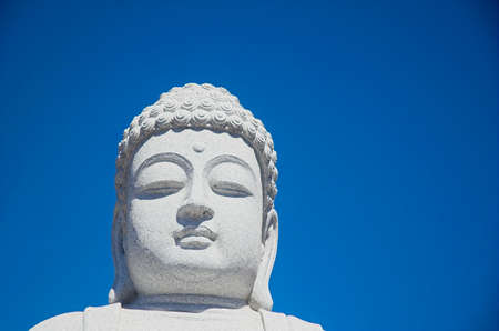 buddha against a blue sky backgroundの写真素材