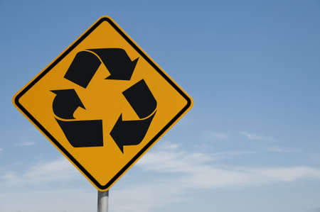 Recycling symbol on a road sign against a blue sky backgroundの写真素材