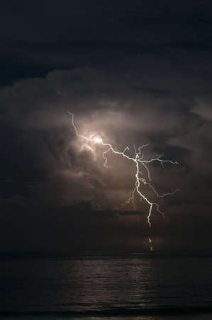 Brilliant forked lightning over the oceanの写真素材