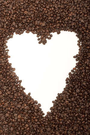 white heart shape in the middle of coffee beansの写真素材
