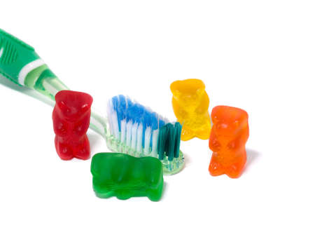 A picture of a toothbrush and some gummi bears to promote teeth cleaning.の写真素材