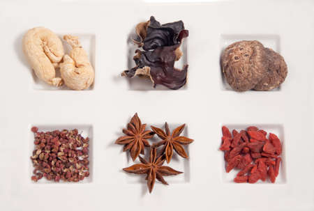 clockwise, l to r: gingseng, wood ear, shitake mushroom, szechuan pepper corn, star anise, dried medlarの写真素材