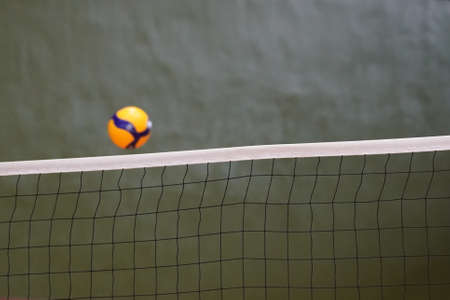 Volleyball and volleyball net floating in the airの写真素材