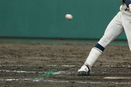 A left-hander at the moment of hitting a ball thrown by a pitcher during a baseball game.の写真素材