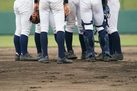 Pitcher, catcher and other infielders gather on the mound during a baseball game.の写真素材