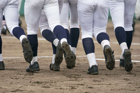 Baseball players dash to line up in front of home base as a baseball game begins.の写真素材