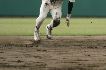 Baseball player running at full speed for the next base during a baseball gameの写真素材